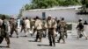 A police officer scuffles with a protester during clashes in Lahore, Pakistan. Police clashed with followers of an anti-Taliban cleric critical of the government in the eastern city, leaving at least seven people killed, officials said.