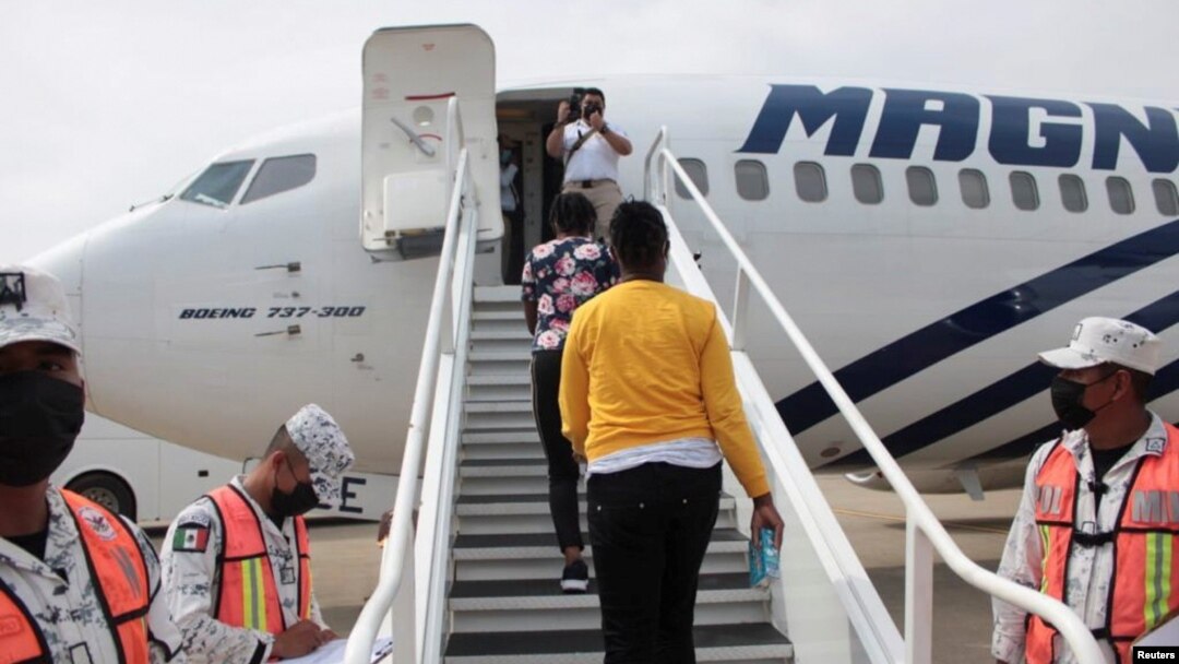 Haitian migrants board a plane as part of the "assisted voluntary return" to Haiti by Mexican authorities, at the Carlos Rovirosa Perez International airport, in Villahermosa, Mexico, Sept. 29, 2021.