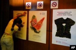 Posters about missing people are placed on a wall for the presentation of a report about the country’s 1965-90 “dirty war” by Mexico's governmental Truth Commission in Mexico City, Aug. 16, 2024.