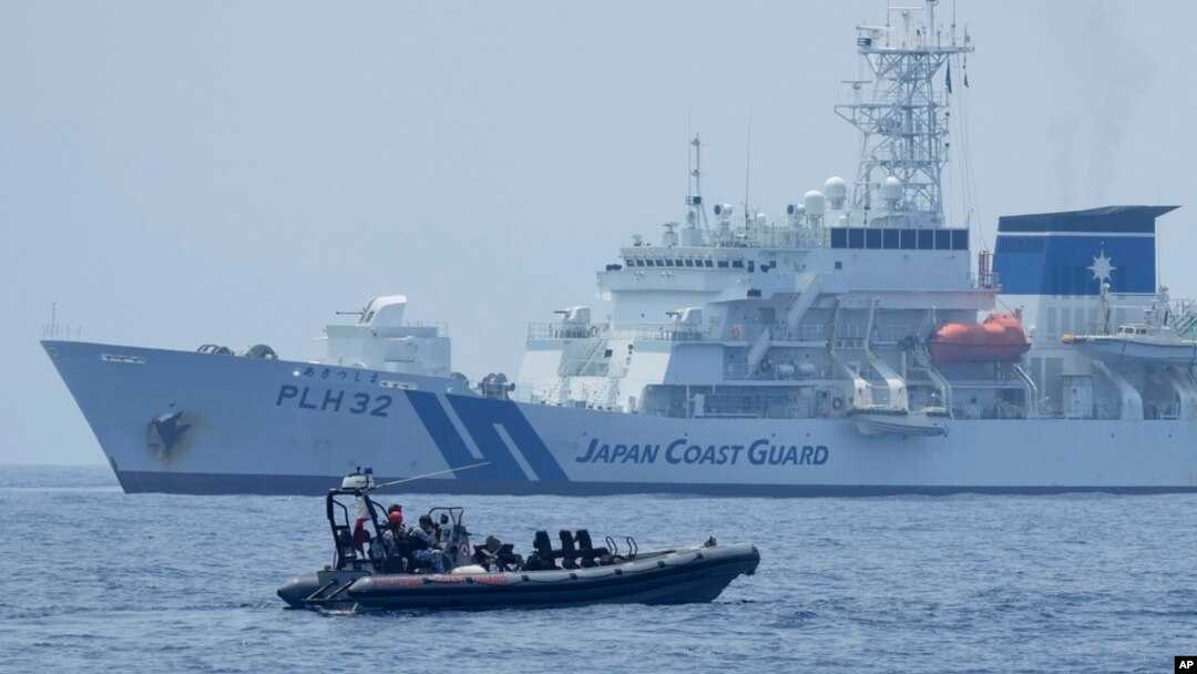  FILE - A Philippine Coast Guard vessel passes by the Japanese Coast Guard Akitsushima during a trilateral Coast Guard drill of the U.S., Japan and Philippines, near the waters of the disputed South China See in Bataan province, Philippines, June 6, 2023. 