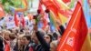 A man holds a rose as people gather outside Spain's Socialist Party headquarters to show support for Prime Minister Pedro Sanchez in Madrid, April 27, 2024. 
