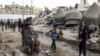 People walk past the rubble of Al-Faruq Mosque, that was destroyed during Israeli bombardment, in Rafah on the southern Gaza Strip on March 17, 2024.