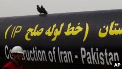 FILE - An Iranian worker walks past the Pakistan-Iran Gas Pipeline Project in Gabd near Pakistani border in Iran, March 11, 2013. 