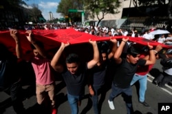 FILE - Demonstrators march in remembrance of the 1968 Tlatelolco student massacre, an event considered part of the Mexico's "dirty war" when the government used its forces to suppress political opposition, in Mexico City, Oct. 2, 2019.