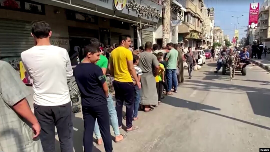 Palestinians wait to buy bread at a bakery, amid the ongoing conflict between Israel and Islamist group Hamas, in Khan Younis in the southern Gaza Strip, October 14, 2023.