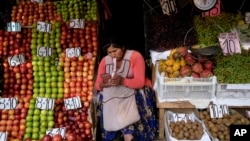 FILE - A vendor waits for customers at her produce stand, a day after Army troops stormed the government palace in what President Luis Arce called a coup attempt, in La Paz, Bolivia, June 27, 2024. 