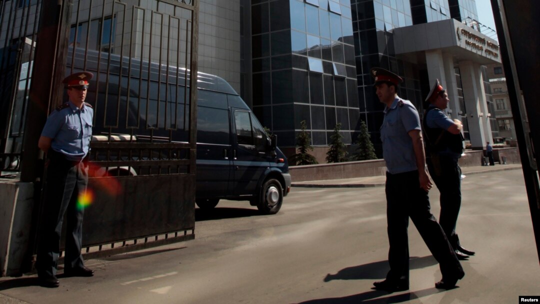 FILE - Interior Ministry officers stand at the entrance to the Investigative Committee of the Russian Federation compound in Moscow, June 15, 2012. 