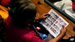 Photos of missing people fill a report by the Guerrero state government during the presentation of a new report about the country’s 1965-90 “dirty war” by Mexico's governmental Truth Commission, in Mexico City, Aug. 16, 2024.