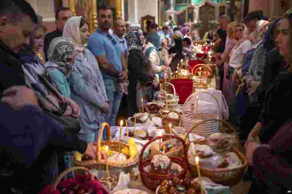 Believers wait for a Lithuanian Orthodox priest to bless their collected traditional cakes and painted eggs prepared for an Easter celebration at the Orthodox Church of the Holy Spirit in Vilnius, Lithuania, May 4, 2024.
