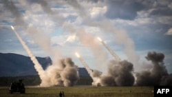 FILE - Missiles launch from a U.S military HIMARS during drills in Shoalwater Bay, Australia, July 22, 2023. The U.S. has announced nearly $1 billion more in military aid to Ukraine. The aid package includes ammunition for HIMARS rocket launchers.
