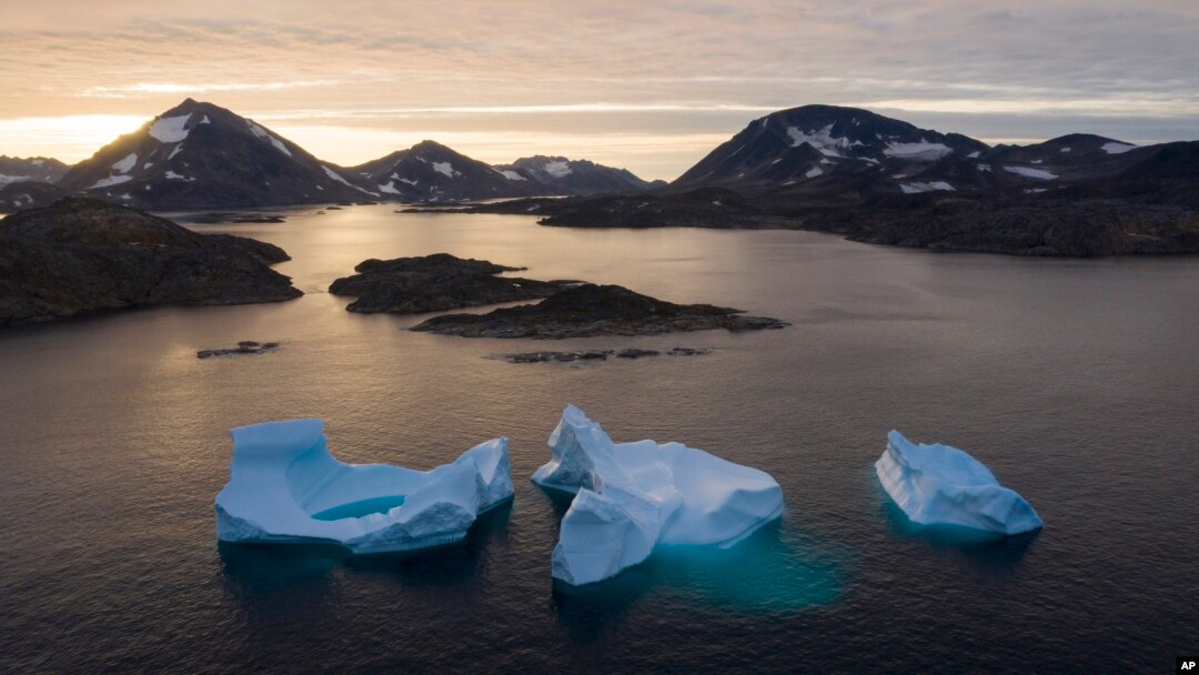 FILE - Large icebergs float away as the sun rises near Kulusuk, Greenland, Aug. 16, 2019. 