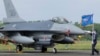 FILE - A Taiwanese Air Force flag bearer passes by an upgraded F-16V fighter jet at the air force base in Chiayi, Taiwan, Nov. 18, 2021. 