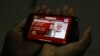 A man in Hyderabad, India watches on his mobile phone Prime Minister Narendra Modi address the nation in a televised speech about COVID-19 situation, April 14, 2020, extending nationwide lockdown through May 3