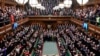 Ukrainian President Volodymyr Zelenskyy is displayed on the screen as he addresses British lawmakers in the House of Commons in London, Thursday March 8, 2022.
