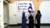 FILE - Afghan women stand outside an amusement park, in Kabul, Nov. 10, 2022. The Taliban ordered NGOs to suspend Afghan female staff for allegedly not wearing the Islamic hijab and breaching mandatory gender segregation at work.