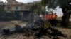 Investigators examine the wreckage of a car at the site of bomb explosion, in Islamabad, Pakistan, Dec. 23, 2022. 