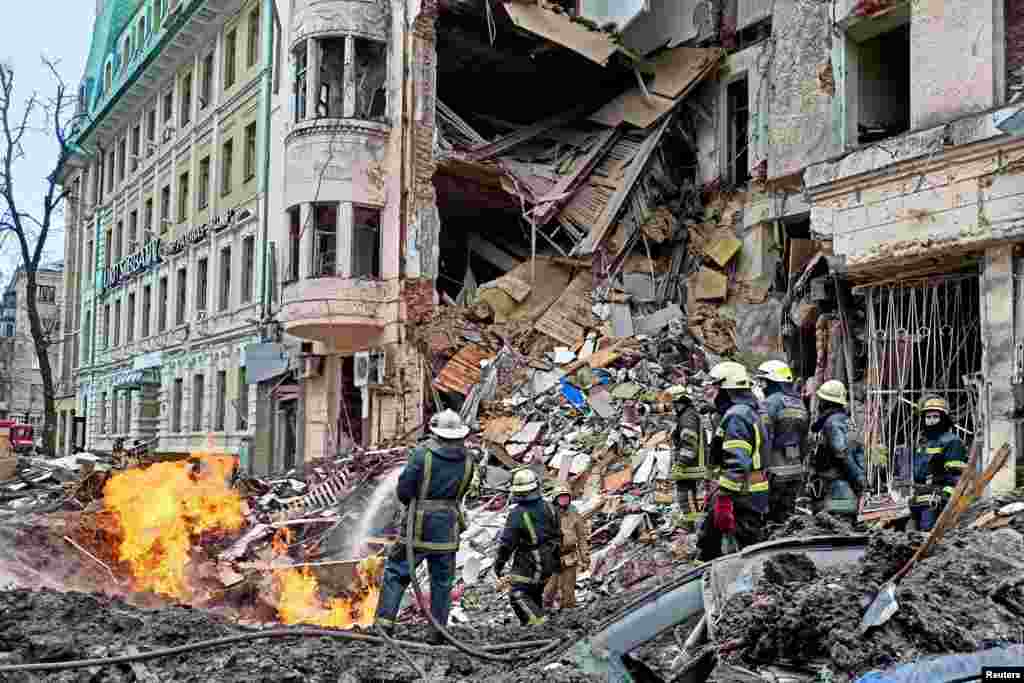 Rescuers work next to a building damaged by airstrike in central Kharkiv as Russia&#39;s attack on Ukraine continues, March 14, 2022.