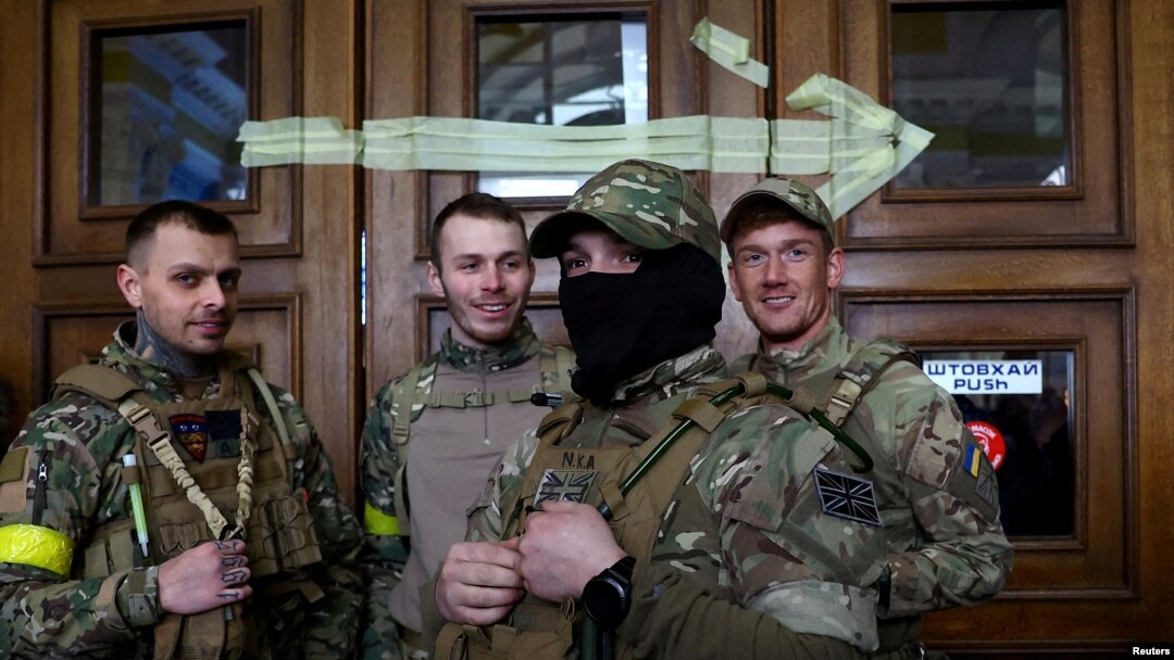 FILE - Four foreign fighters from the UK pose for a picture prior to their departure towards the front line in the east of Ukraine following the Russian invasion, at the main train station in Lviv, Ukraine, March 5, 2022. 