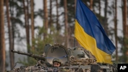 Ukrainian troops in an armored vehicle advance outside Kyiv, Ukraine, March 31, 2022.