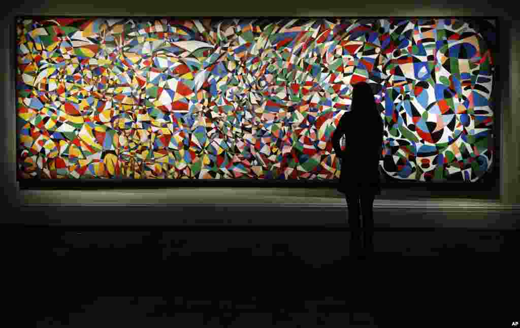 A Sotheby's employee looks at the 'Towards a Sky' painting by Turkish female artist Princess Fahrelnissa Zeid as part of the Middle Eastern Art auction at the auction house Sotheby's in London.