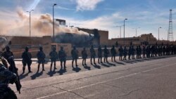 FILE - Iraqi Security Forces members stand guard in front of the U.S. Embassy in Baghdad, Iraq, Jan. 1, 2020.