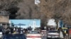 FILE - Members of the Taliban stand guard at the entrance gate of Kabul University in Kabul, Dec. 21, 2022. 