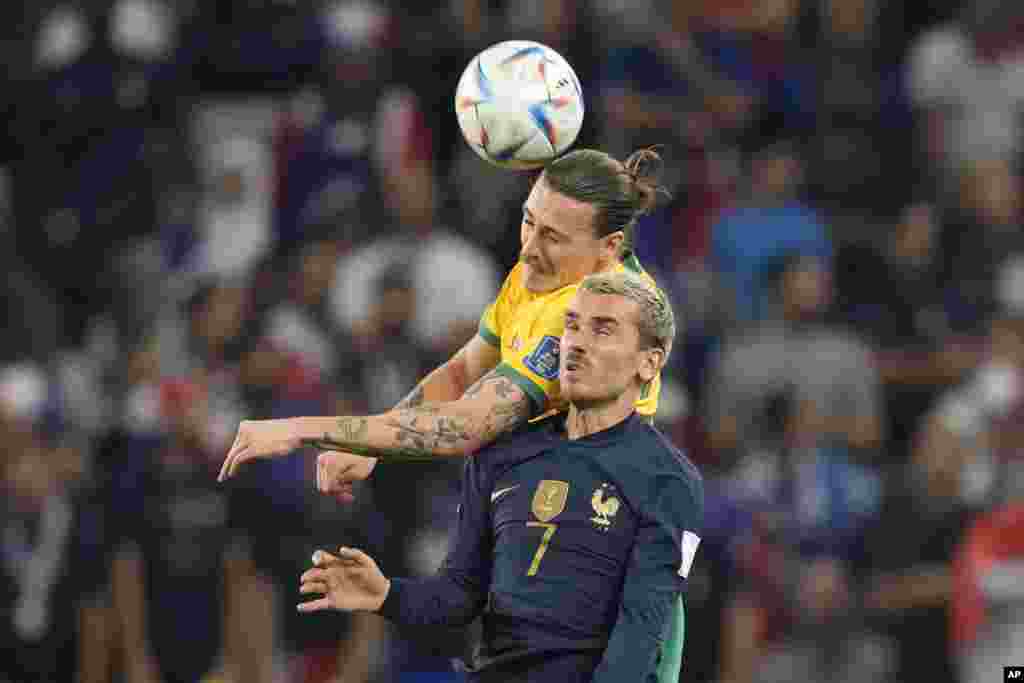 Jwe Franse Antoine Griezmann devan ak Ostralyen Jackson Irvine goumen pou balon an nan match La Frans kont Ostrali nan Gwoup D a nan Mondyal la, 22 Nov. 2022.