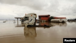 FILE - Vehicles are seen submerged in flood water at a petrol station in Lokoja, Nigeria, Oct. 13, 2022. 