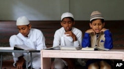 FILE - Indian Muslim children read the Quran at a madrasa or a religious school, in Bangalore, India, Oct. 3, 2015. 