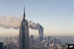 2001年9月11日，一架被劫持的飞机撞上纽约世界贸易中心的塔楼后，高楼起火冒烟。