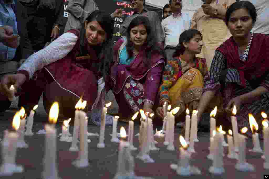 Members of a civil society group light candles during a vigil for the victims of Sunday's suicide bombing, March 28, 2016 in Karachi, Pakistan.
