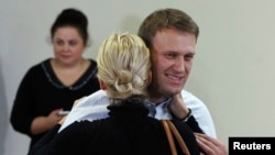 Russian opposition leader Alexei Navalny embraces his wife Yulia after the announcement of the verdict, Oct. 16, 2013. 