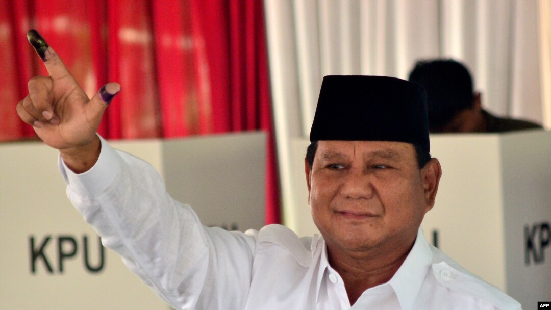 Presidential challenger Prabowo Subianto shows off his ink-dyed finger after casting his vote in Indonesia's general election at a polling station..