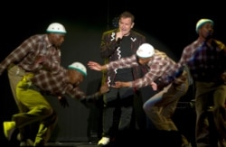 In this photo taken Saturday, July 2017, South African musician Johnny Clegg, middle, and the dancers perform during "The Final Journey" concert at the Grand Arena in Cape Town, South Africa.
