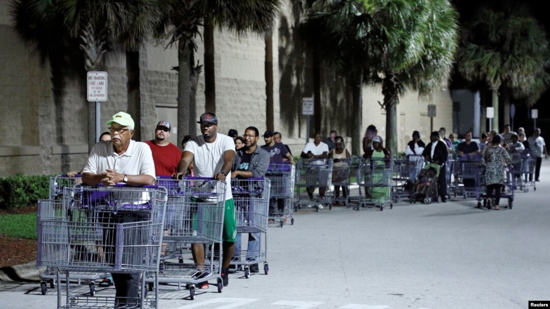 Shoppers wait in a long line for a Sam's Club store to open before sunrise, as people rushed to buy supplies ahead of the arrival of Hurricane Dorian in Kissimmee, Florida, Aug. 30, 2019. 