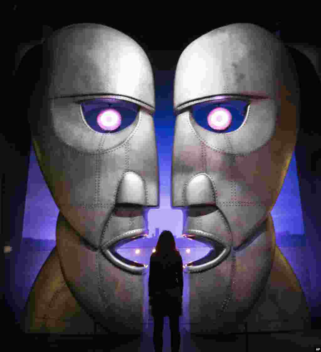 A museum worker poses in front of the metal heads from The Pink Floyd&#39;s Division Bell album at the band&#39;s exhibition, &#39;Their Mortal Remains&#39;, at the V&amp;A museum in west London.