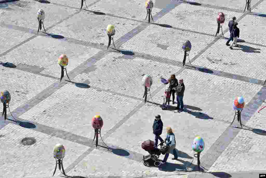 People look at huge Easter eggs as they walk in the open-air festival in the center of Kyiv, Ukraine.