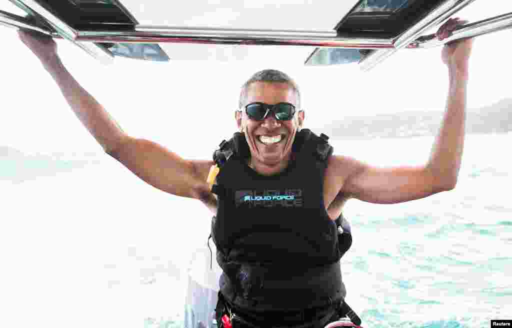 Former U.S. President Barack Obama sits on a boat during a kite surfing with British businessman Richard Branson during a vacation on Branson's Moskito island, in the British Virgin Islands, in a picture handed out by Virgin.
