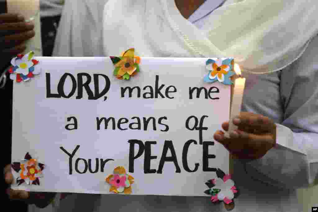 A Pakistani nun holds a candle during a vigil for victims of the Sunday's deadly suicide bombing in a park, March 28, 2016 in Lahore, Pakistan.