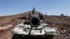 A frontal view of a tank barrel is seen as Shi'ite Houthi rebels stand on its turret, after they took over the compound of the army's First Armored Division in Sana'a, Yemen, Sept. 22, 2014. 