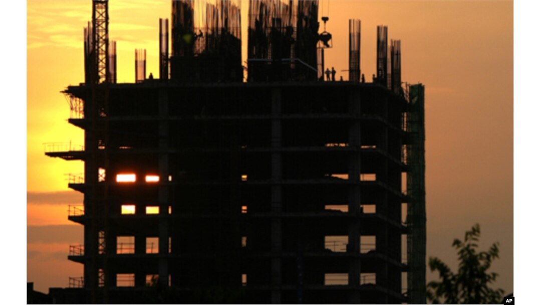 FILE - Construction workers work on a new building in Phnom Penh, Cambodia