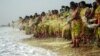 FILE - Indian women throw flowers into the sea as an offering during a ceremony for the victims of the 2004 tsunami at Marina Beach in Chennai, Dec. 26, 2016.