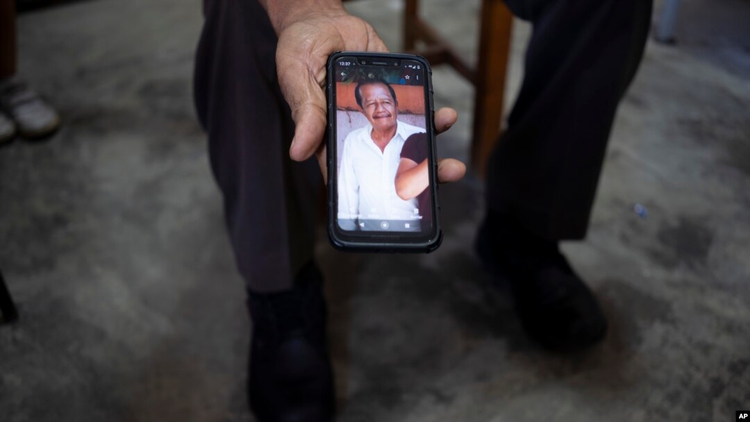 A bus driver shows photo of late coworker Nehemias Verdugo Trejo who was killed by gunmen in Feb. 24, 2022, at a bus station in Huixtla, Mexico, Jan. 19, 2023.