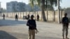 FILE - Security officials guard a blocked road leading to a counter-terrorism center after security forces starting to clear the compound seized earlier by Pakistani Taliban militants in Bannu, a northern district in the Pakistan's Khyber Pakhtunkhwa province, Dec. 20, 2022.