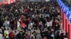 广东深圳南站大厅内，旅客们人们带着口罩和行李，熙熙攘攘挤满大厅，等待买票和登车。（2023年1月7日）