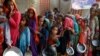 FILE - Flood victims gather to receive food in a camp, following rains and floods during the monsoon season in Sehwan, Pakistan, Sep.14, 2022. 