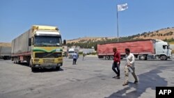 FILE - A convoy transporting humanitarian aid crosses into Syria from Turkey through the Bab al-Hawa border crossing on July 8, 2022.