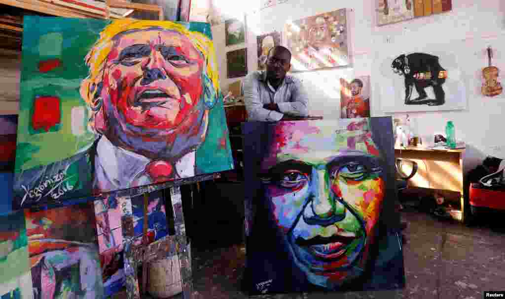 Kenyan artist Evans Yegon alias "Yegonizer" poses for a photograph in front of his paintings of U.S. President-elect Donald Trump and U.S. President Barack Obama at his studio inside the GoDown Art Center in Nairobi.
