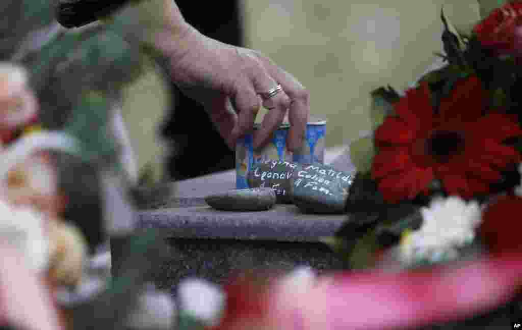 A Jewish woman leaves stones and candles at a monument dedicated to the Macedonian Jews, victims of the Holocaust, at a cemetery in Skopje, Macedonia. The Jewish community marks the 74th anniversary since the deportation of 7,144 Macedonian Jews, almost the entire Jewish population in Macedonia at that time, to the Nazi extermination camp Treblinka, where they were all killed during World War II.