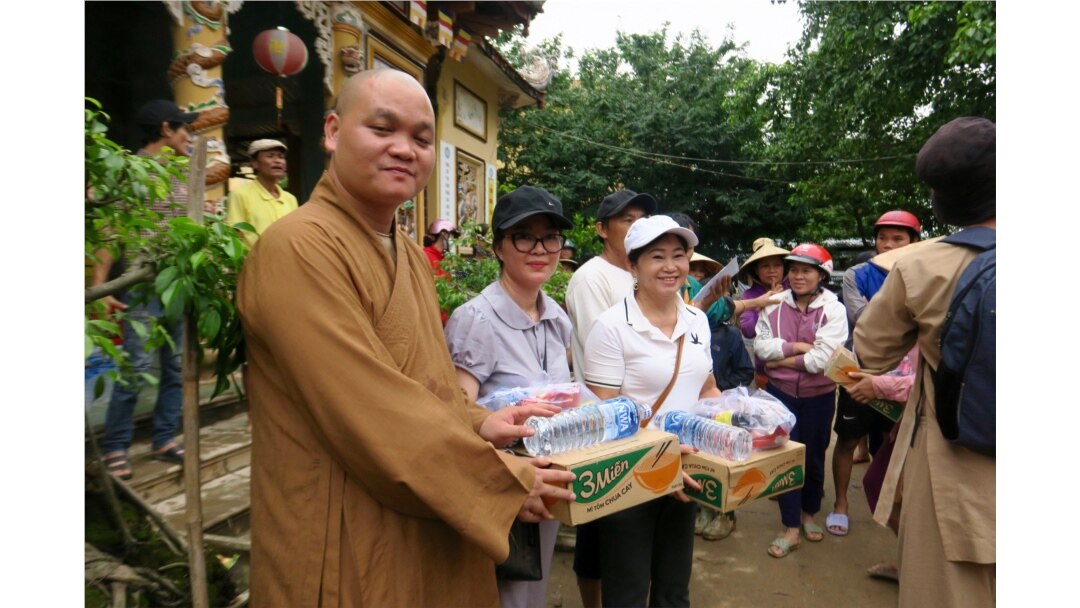A monk hands out food supplies to locals in a pagoda in Quang Tri.